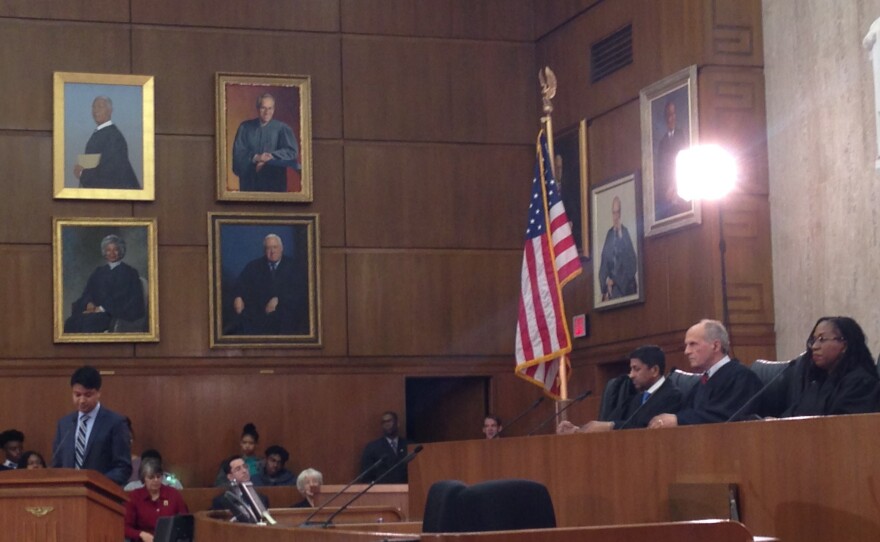 Law clerk Zayn Siddique, at the lectern, argues as the lawyer for Tinker, before Judges Sri Srinavasan, David Tatel and Ketanji Jackson.