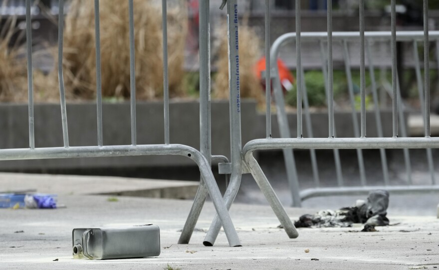 A metal can sits on the ground at the scene where a man lit himself on fire in a park outside Manhattan criminal court on Friday in New York.