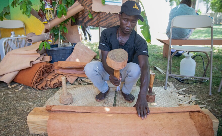 Aloyzius Luwemba, a 10th-generation barkcloth maker, uses a ridged wooden mallet to beat the barkcloth canvas so that it expands in size.