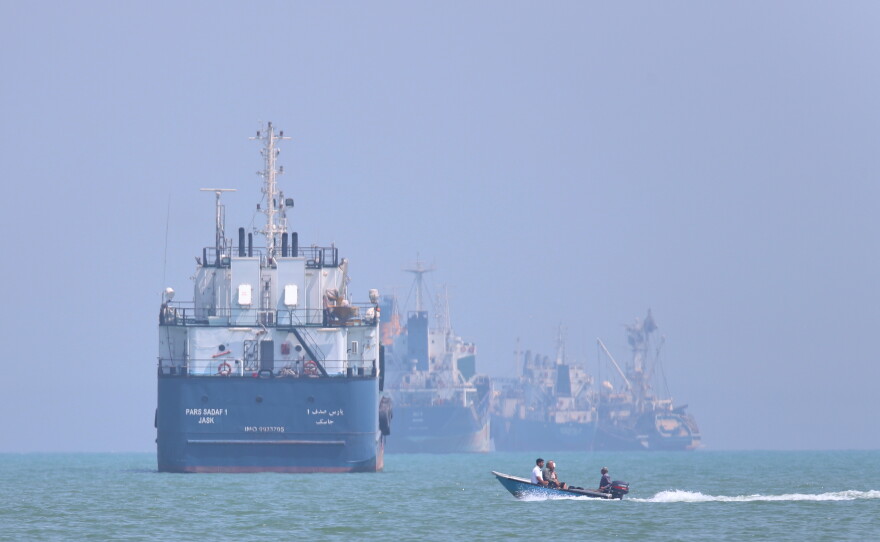 A small motorboat passes anchored vessels in the Strait of Hormuz off Bandar Abbas, Iran, Thursday, June 11, 2026.
