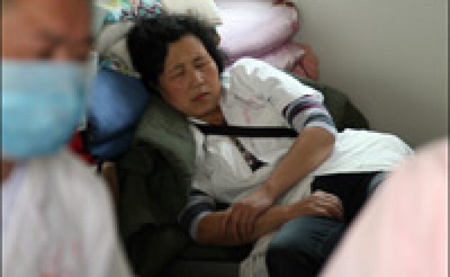 A medical worker catches a nap in the vast evacuee camp in Mianzhu.
