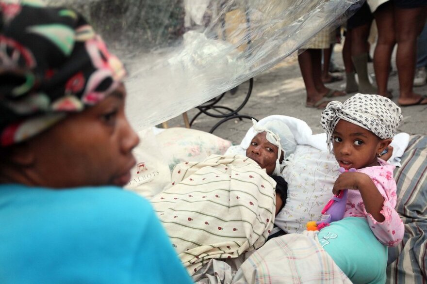 Injured people rest in the streets of Port-au-Prince Thursday, two days after the devastating 7.0 quake.