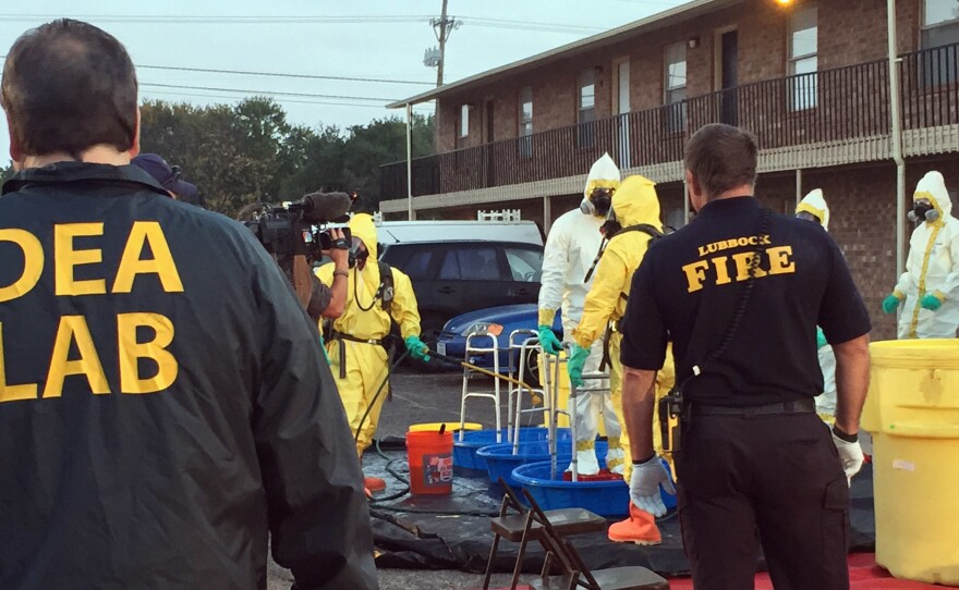 U.S. Drug Enforcement Agency, Lubbock Fire Department personnel help members of the DEA Hazardous Materials/Clandestine Laboratory Enforcement Team with a decontamination procedure in Lubbock, Texas in Oct. 2017.