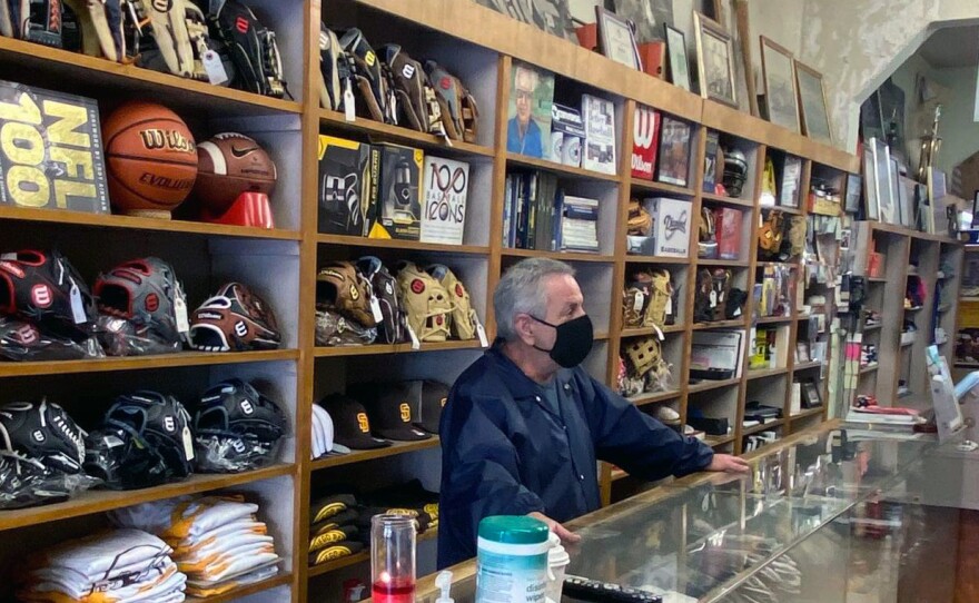 Gregg Schloss stands behind the counter on the last day A&B Sporting Goods in North Park was open, Jan. 2021.