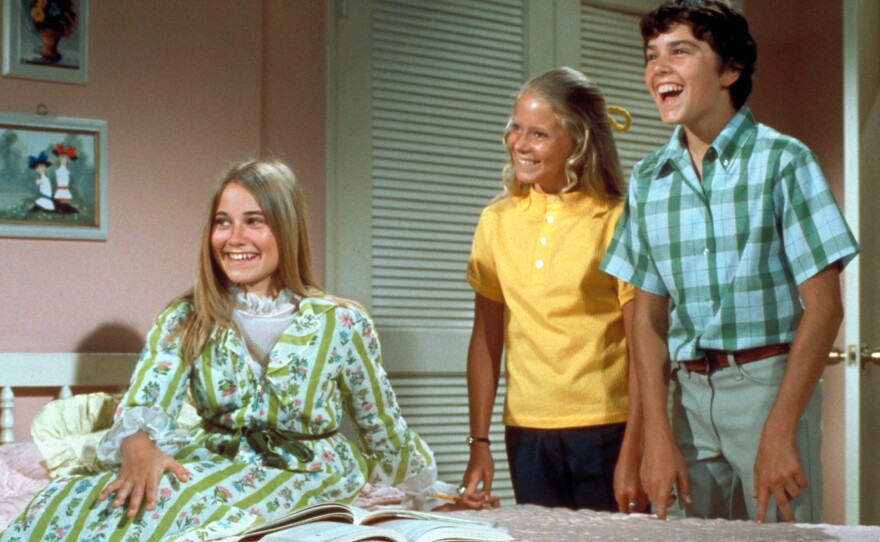 The Brady Bunch Circa 1970, with Marcia seated in front. In one episode of the show from 1969, the sisters and brothers all stay home from school with the measles.
