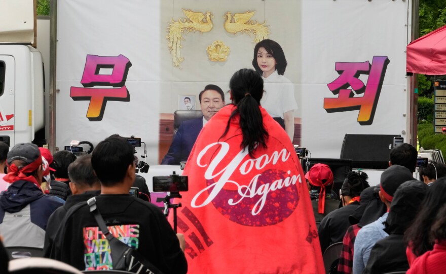 An image of former South Korean President Yoon Suk Yeol and his wife Kim Keon Hee is seen during a rally by supporters outside of the Seoul High Court in Seoul, South Korea, Tuesday, April 28, 2026. The letters read "Not Guilty."