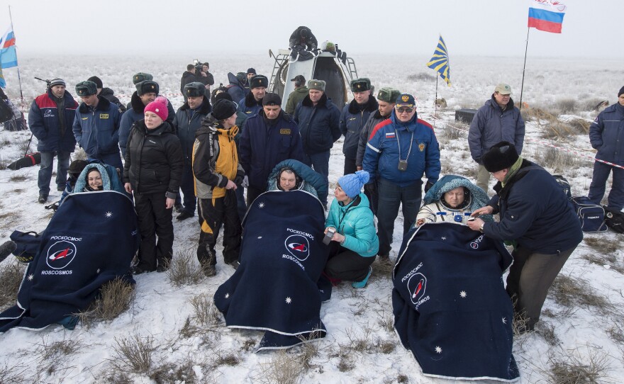 Expedition 42 Cosmonauts Elena Serova, left, and Alexander Samokutyaev, center, sit in chairs along with NASA astronaut Barry Wilmore, minutes after they landed back on Earth.