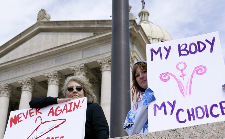 Dani Thayer, left, and Marina Lanae, right, both of Tulsa, Okla., hold pro-choice signs at the state Capitol, Wednesday, April 13, 2022, in Oklahoma City.