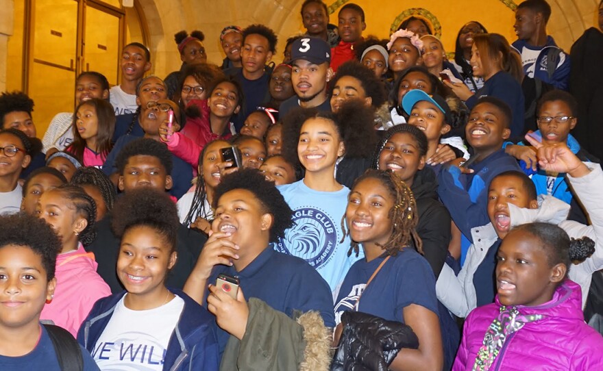 A group of students from the National Teachers' Academy pose for a picture with artist Chance the Rapper.