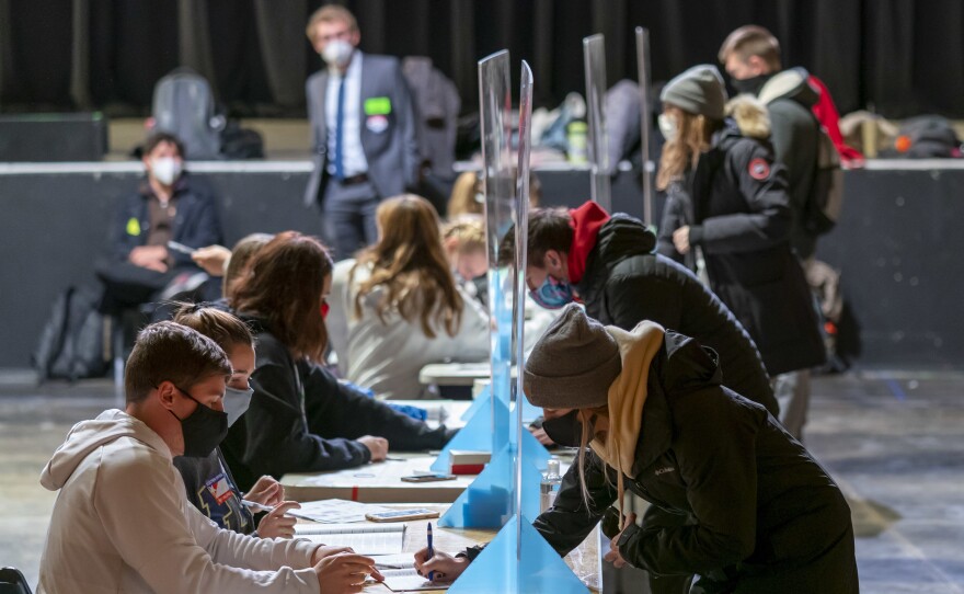 Poll workers check voters identifications at The Orpheum Theater in Madison, Wis., on Election Day. The Trump campaign announced on Wednesday that it is filing for a recount in two counties in the state.