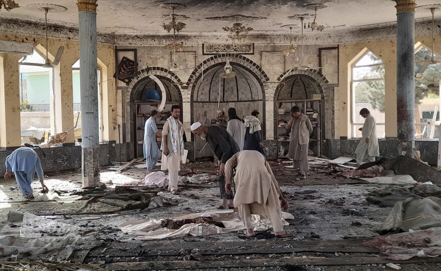 People view the damage inside of a mosque following a bombing in Kunduz, province northern Afghanistan, on Friday.