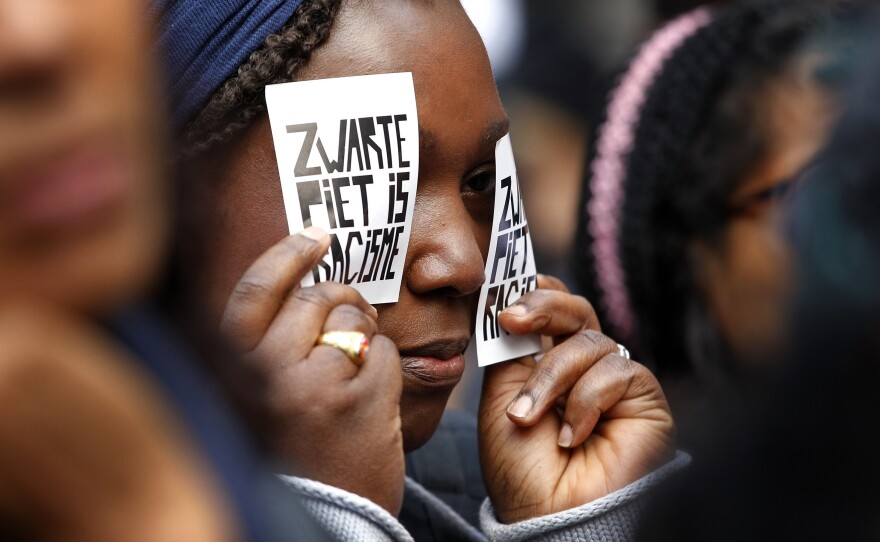A demonstrator holds a sign reading "Black Pete Is Racism" during a 2013 demonstration in Amsterdam. Zwarte Piet or Black Pete is traditionally depicted by white people wearing blackface, Afro wigs and red lipstick.