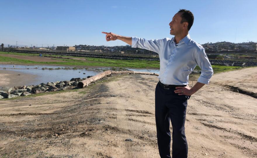 Rafael Castellanos, a candidate for San Diego County’s first supervisorial district, points toward what he says is polluted water in the Tijuana River Valley, Jan. 22, 2020.