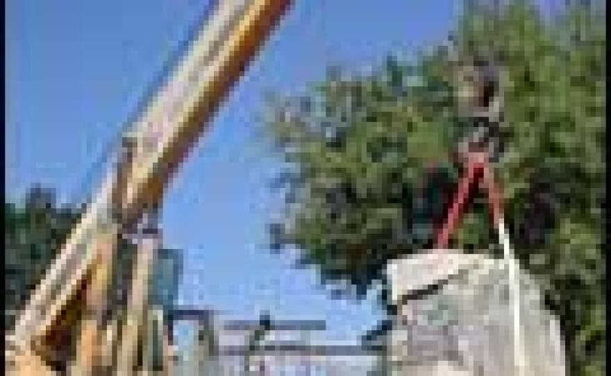 A crane lifts a limestone disk into place on a reconstructed column in Nemea.