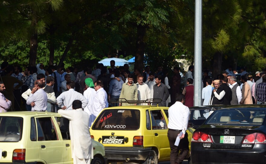 Pakistani federal employees gather outside their offices after a 7.5-magnitude earthquake in Islamabad on Monday.