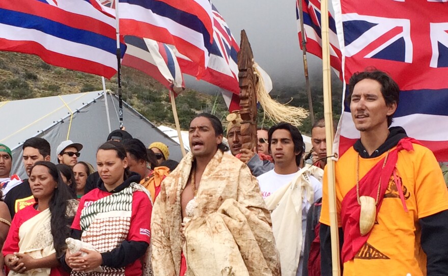 Telescope opponents Lanakila Manguil (center) and Kahookahi Kanuha (right) lead a pule, or prayer, atop Mauna Kea.