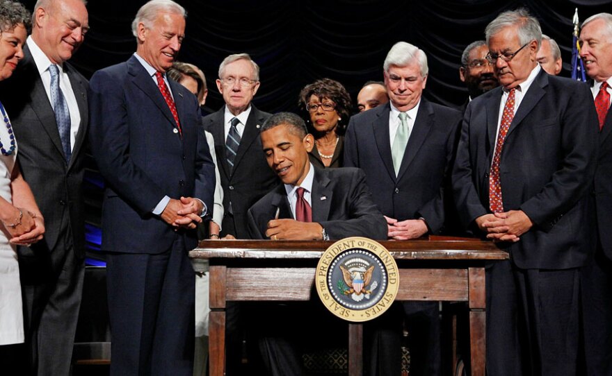 President Obama signs the the financial bill into law during a ceremony Wednesday at the Ronald Reagan Building and International Trade Center in Washington, D.C.