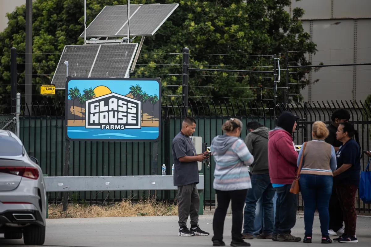 Families wait outside the front gates of the Glass House Farms facility outside Camarillo on July 11, 2025. Glasshouse Farms was the site of an immigration raid by federal immigration agents just a day prior, on July 10.