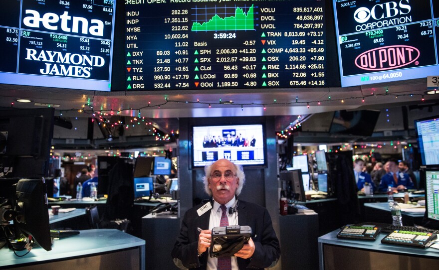 A New York Stock Exchange trader works on the floor on Dec. 17. Stocks rose nearly 300 points after the Federal Reserve announced it plans to begin raising interest rates next year.