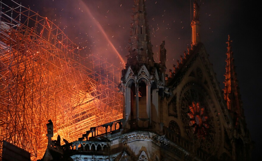 Sparks fill the air as Paris fire brigade members spray water to extinguish flames on Monday.