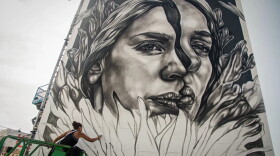 An artist works on a mural at KAABOO 2017 at the Del Mar Racetrack and Fairgrounds in San Diego in 2017.
