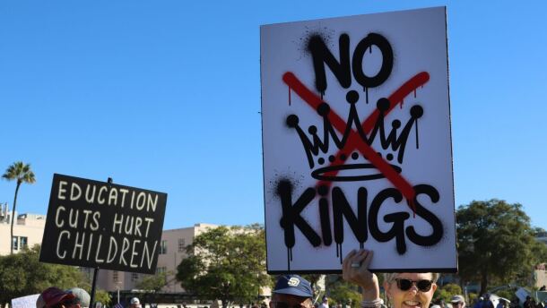 Protesters hold up signs during a demonstration for a 'No Kings' rally in San Diego on Oct. 18, 2025. 