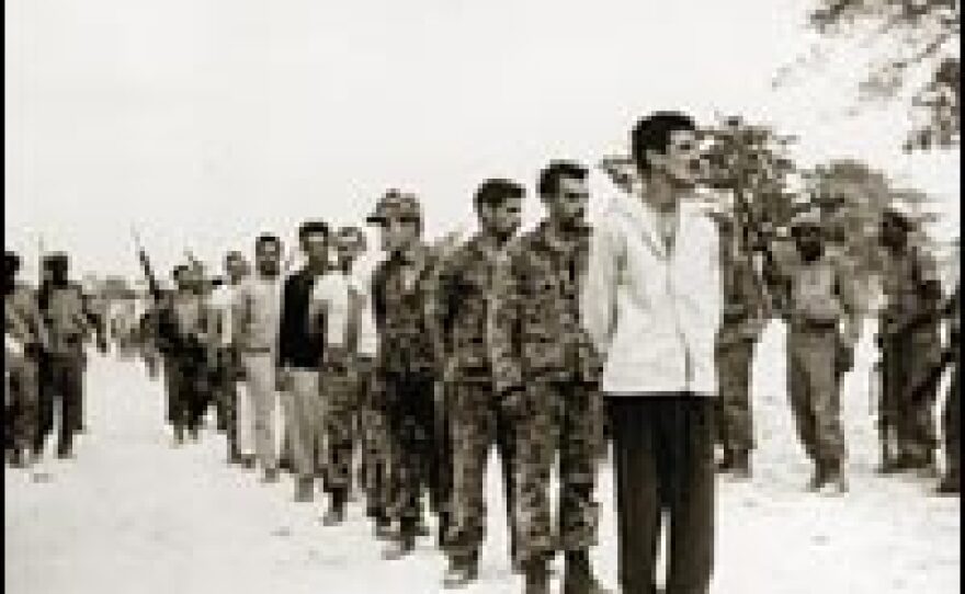 A group of captured Cubans, part of a U.S.-backed force of Cuban exiles who attempted an invasion of Cuba at the Bay of Pigs, are lined up by Castro's soldiers on the Playa de Giron, Cuba, in 1961.