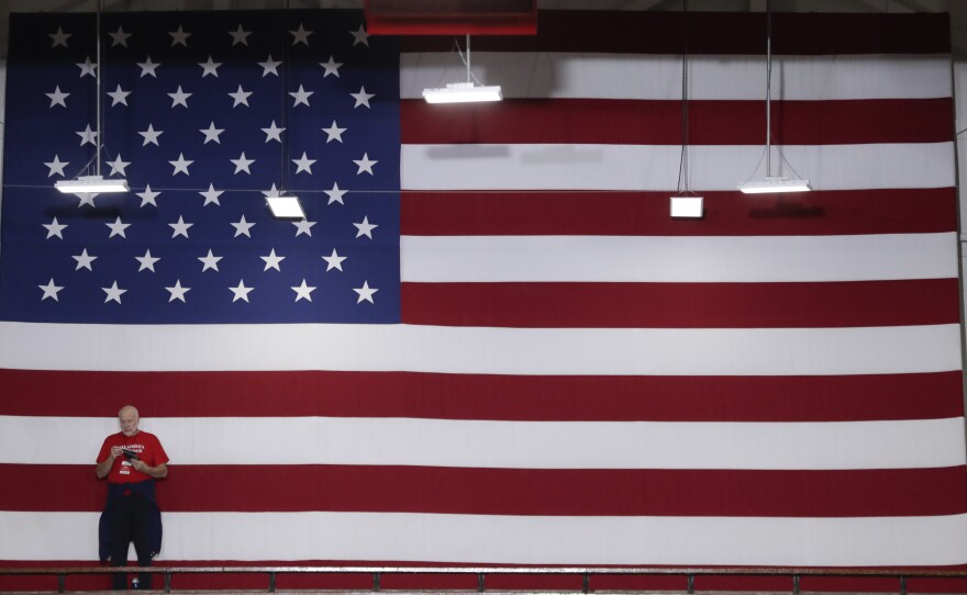 A volunteer stands in front of an American flag before President Trump speaks at a rally last week in Indianapolis. Indiana is a key Senate battleground state for the GOP.