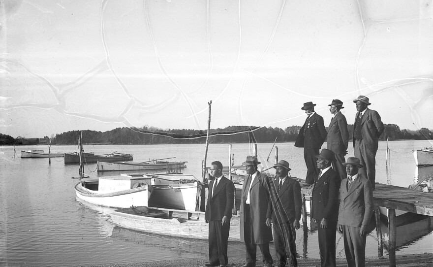 Men gather near a dock.