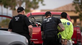 A U.S. Immigration and Customs Enforcement (ICE) officer detains a man during an operation in Escondido on July 8, 2019.