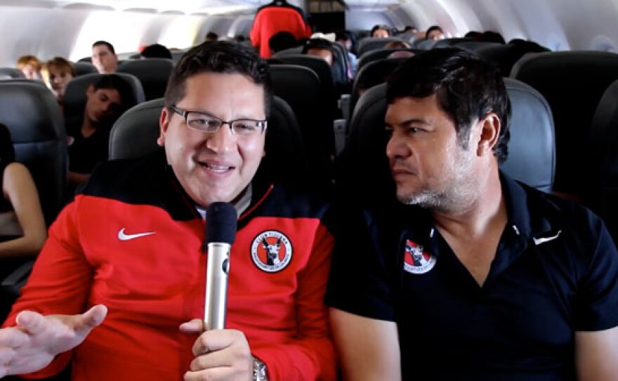 Host Jorge Meraz interviews the Xolos coach Daniel Guzman on the plane as they travel to play against the Chivas at the Omnilife stadium in Guadalajara.