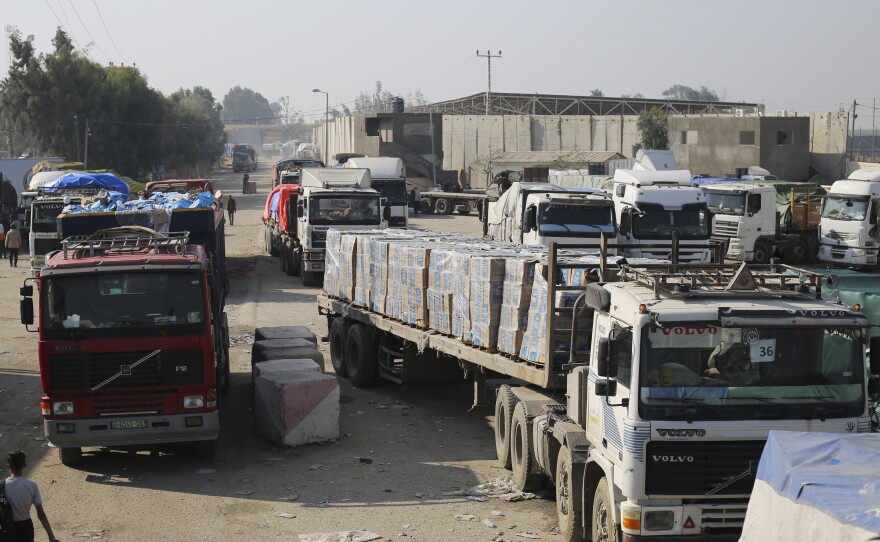 Aid trucks enter through the Kerem Shalom crossing from Israel into the Gaza Strip on Dec. 18. The Security Council's vote on a new U.N. resolution to spur desperately needed aid to Gaza went through intense negotiations around two issues important to the U.S. — a reference to a cessation of hostilities and putting the U.N. in charge of inspecting trucks.