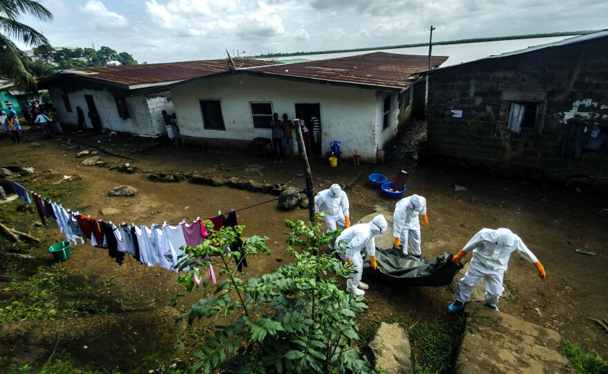 A team of body collectors carry the corpse of a woman suspected of dying of Ebola in Monrovia, Liberia's capital.