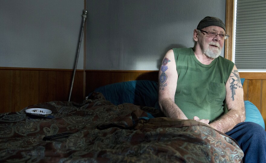 Rusty Welton sits on his bed inside his home. He isn't convinced that a cooperative is the best plan.