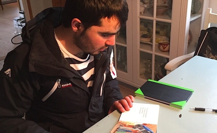 Waliullah Hafiz reads a children's book as he teaches himself Swedish.
