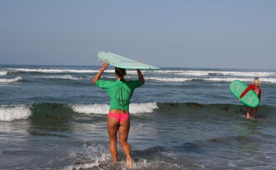 Kelly Harris heads out for her heat during the "Return to the Reef "Invitational at Cardiff Reef Beach, Oct. 2014.