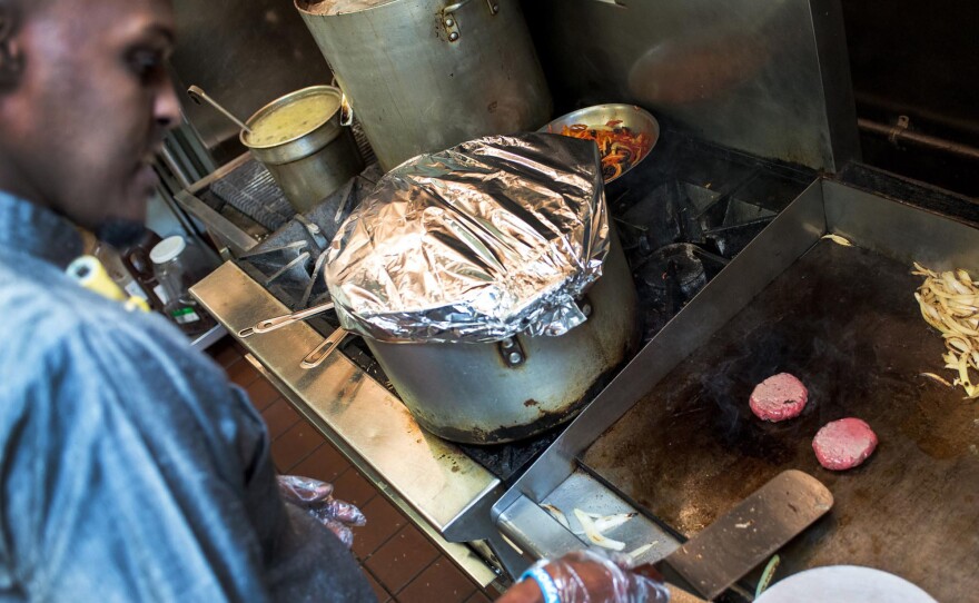 Hashi cooks camel meat during a demonstration at Safari Restaurant. He will be offering camel sliders at his newest Minneapolis restaurant, set to open in late February.