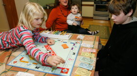 A family plays Monopoly in the kitchen of their home in Jericho, Vt.