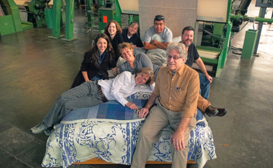 The Oriole Mill staff with their bedding products. At the Oriole Mill in Hendersonville, North Carolina, American textile manufacturing is thriving once again. 