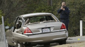 A California Highway patrol officer photographs a vehicle involved in a deadly shooting rampage at the Rancho Tehama Reserve, near Corning, Calif., Tuesday, Nov. 14, 2017. 