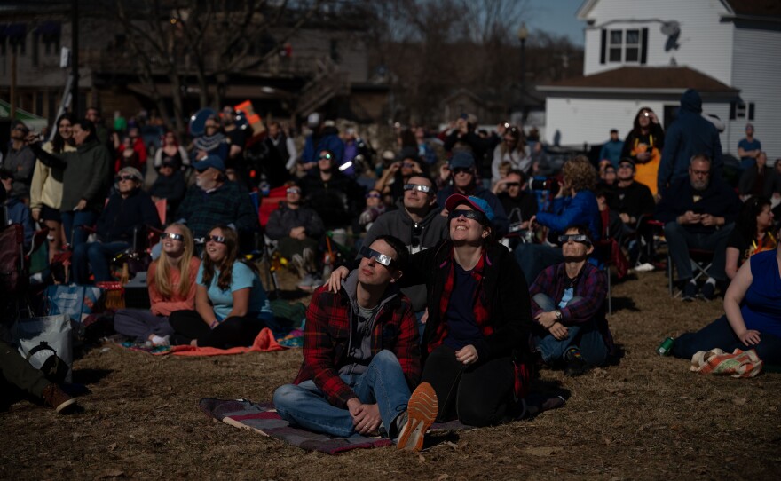 People watch as the total solar eclipse begins in Millinocket, Maine, on Monday.