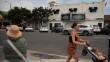 A woman pushes her daughter in a stroller in front of the vacant Carlsbad Theater, August 2025.