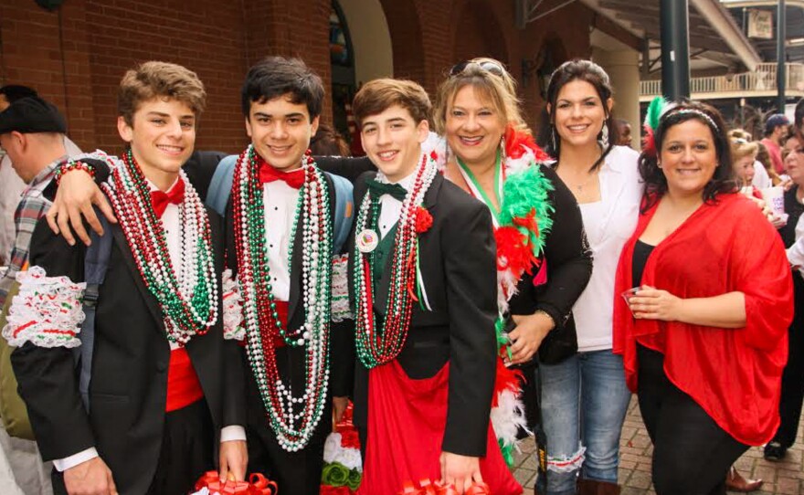 As they travel the parade route, tuxedoed men and youths distribute strings of colorful beads, dried fava beans and genuine Italian kisses.
