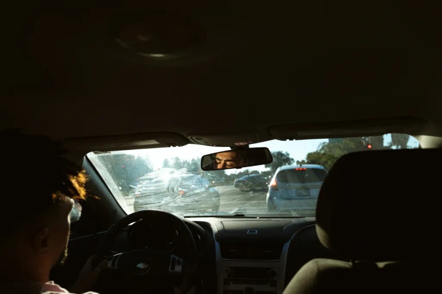 Jodeah Wilson waits at a red light while driving his new car through Sacramento on Oct. 17, 2025. When his previous car broke down, he kept it a secret from his father for months because he was determined to figure out the situation on his own.