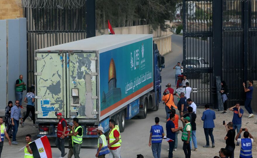 People on the Egyptian side of the Rafah border crossing watch as a convoy of lorries carrying humanitarian aid crosses to the Gaza Strip on Sunday.