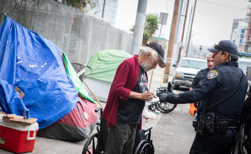 San Diego police give a citation to a man who was staying in a tent on the sidewalk of Commercial Street. San Diego, Calif. June 9, 2022.