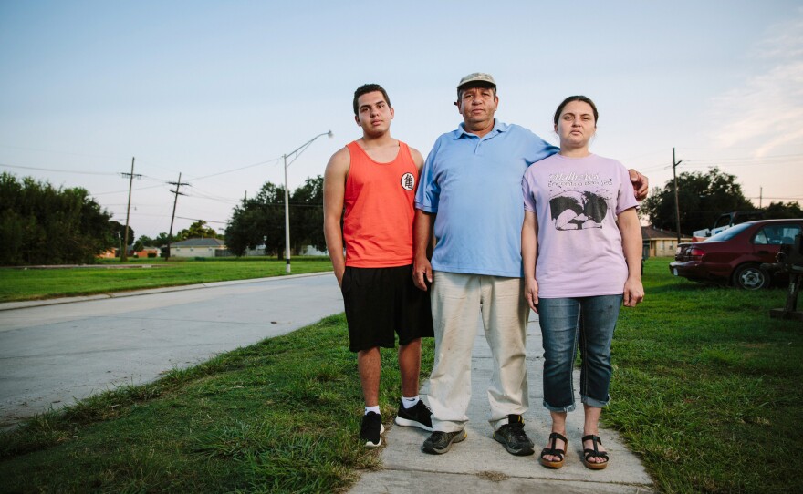 Igor Depaula, 17, father Jose Depaula, 50, and mother Francisca Depaula, 35, pose for a portrait on the sidewalk near their home on Schnell Drive.