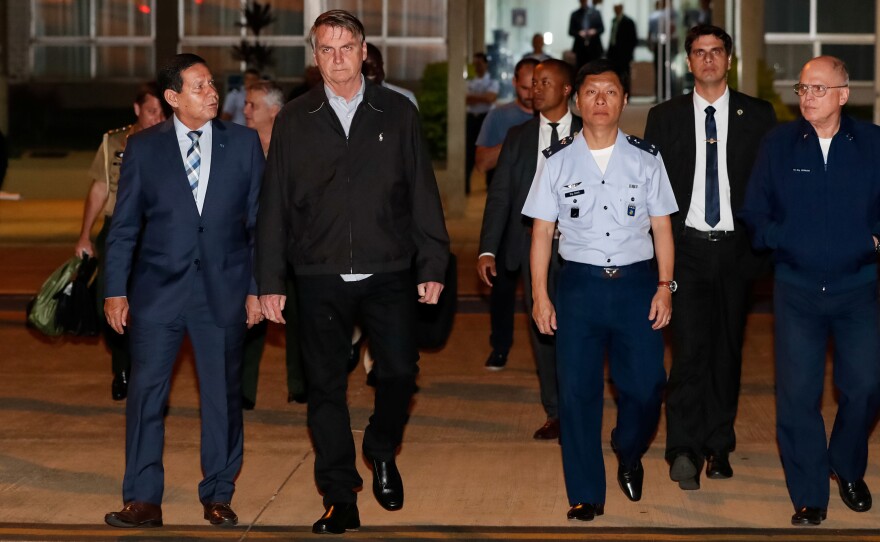 Brazilian President Jair Bolsonaro is calling for severe punishment after 86 pounds of cocaine were found in the luggage of an advance plane for his trip to Japan. Bolsonaro (center) is seen here preparing to leave for this week's G-20 meeting in Osaka.