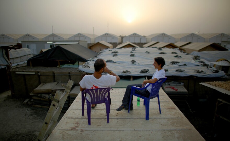 Dr. Nav and Dickerson take a break on the roof of a shipping container at sundown.