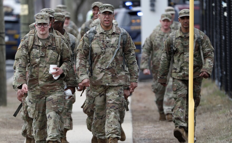 National Guard personnel march in formation Thursday at a state-managed coronavirus drive-through testing site that just opened on Staten Island in New York.
